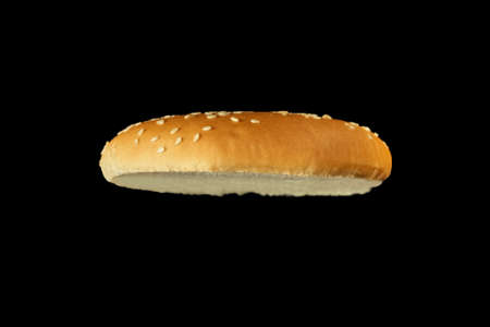 Slice of burger bun isolated on black background.の写真素材