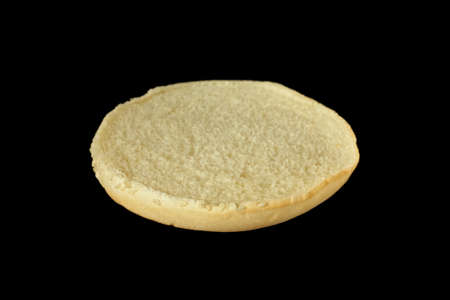Slice of burger bun isolated on black background.の写真素材
