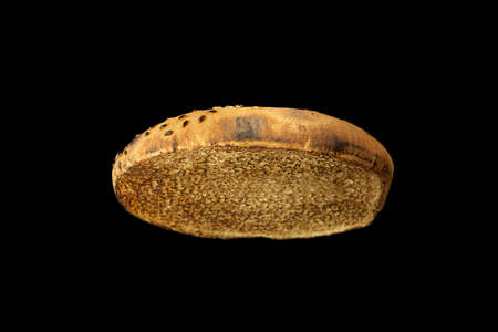 Toasted slice of burger bun isolated on black background.の写真素材