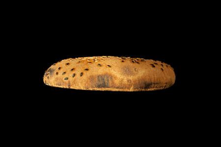 Toasted slice of burger bun isolated on black background.