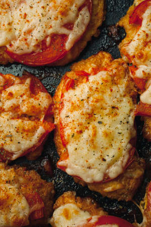Baked chicken fillet with cheese and tomato on a baking tray for roasting. Meat dish for the festive table.の写真素材