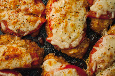 Baked chicken fillet with cheese and tomato on a baking tray for roasting. Meat dish for the festive table.の写真素材