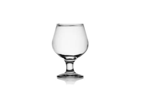 Empty cognac glass isolated on a white background without glare. Reflection on the surface. Back light.の写真素材