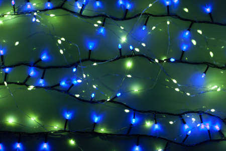 Christmas, festive background with glowing garland. Colorful lights on a dark background. New Year cards, postcard, banner. With space for text. Soft focus.の写真素材