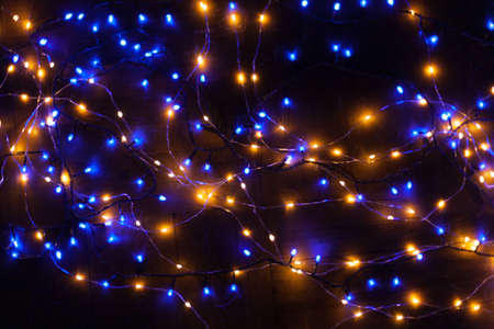 Christmas, festive background with glowing garland. Colorful lights on a dark background. New Year cards, postcard, banner. With space for text. Soft focus.の写真素材