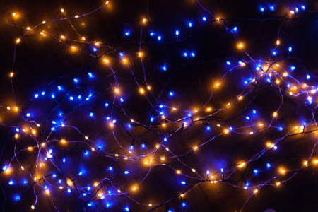 Christmas, festive background with glowing garland. Colorful lights on a dark background. New Year cards, postcard, banner. With space for text. Soft focus.の写真素材