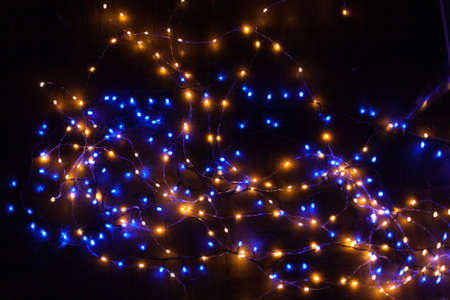 Christmas, festive background with glowing garland. Colorful lights on a dark background. New Year cards, postcard, banner. With space for text. Soft focus.の写真素材