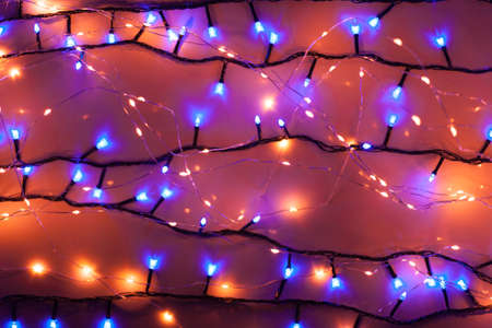 Christmas, festive background with glowing garland. Colorful lights on a dark background. New Year cards, postcard, banner. With space for text. Soft focus.の写真素材
