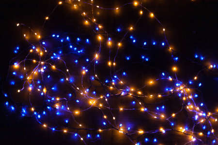 Christmas, festive background with glowing garland. Colorful lights on a dark background. New Year cards, postcard, banner. With space for text. Soft focus.の写真素材