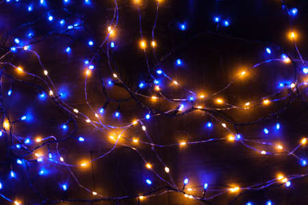 Christmas, festive background with glowing garland. Colorful lights on a dark background. New Year cards, postcard, banner. With space for text. Soft focus.の写真素材