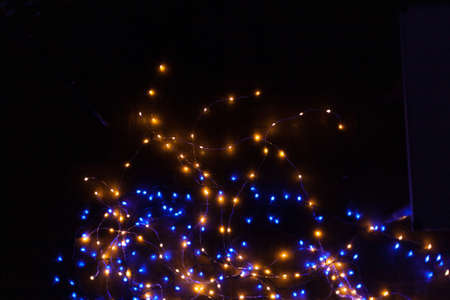 Christmas, festive background with glowing garland. Colorful lights on a dark background. New Year cards, postcard, banner. With space for text. Soft focus.の写真素材