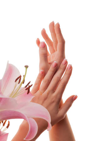 Female hands with French manicure and lily flowers isolated on white background.の写真素材
