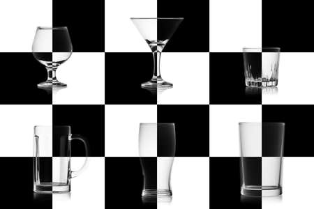Set of different empty glasses for alcoholic drinks isolated on the chessboard. Glassware game concept for alcohol.の写真素材