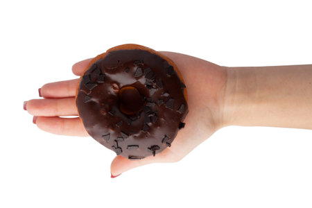 Female hand holds with fingers a chocolate brown donut in glaze isolated on white background.の写真素材
