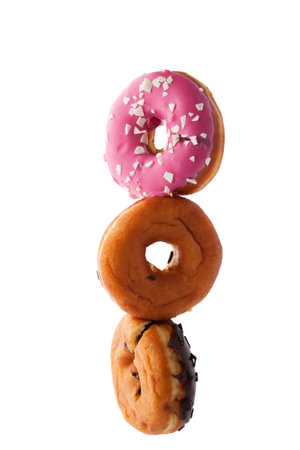 Stack of donuts hanging in the air isolated on white background.の写真素材