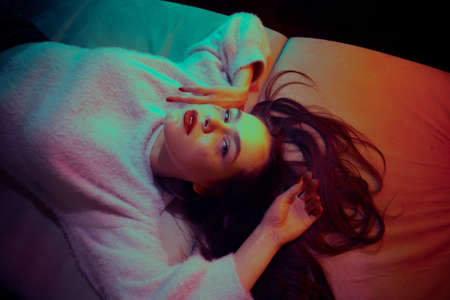 Sexy, beautiful young girl lies on the couch seduces with a look.の写真素材