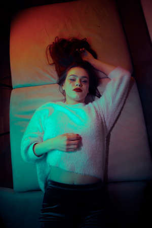 Sexy, beautiful young girl lies on the couch seduces with a look.