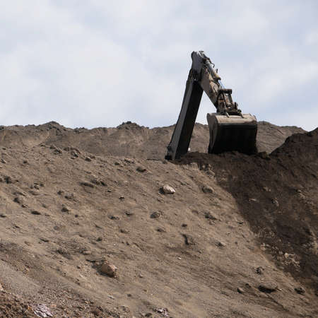 Excavator works on a dump in open pit mining. Heavy construction equipment. Quarry mining.の写真素材