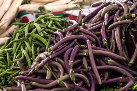 Pile of Japanese eggplants and legumes on a fairの写真素材