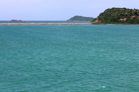 Thailand deep blue sea horizon seascape view at sunshine noon, wide nature scenery travel with white clouds sky. Green ocean wave ripple on windy summer season and small tree rock island landscape.の写真素材