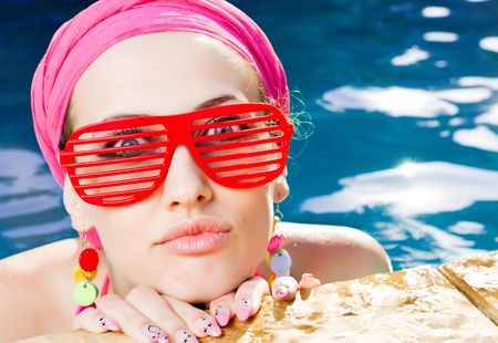 beautiful woman with red sunglasses in the poolの写真素材