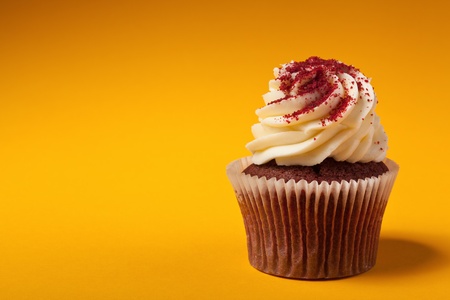 chocolate cupcake with cream isolated on orange background with copyspaceの写真素材