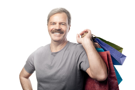 smiling mature man holding shopping bags isolated on white backgroundの写真素材