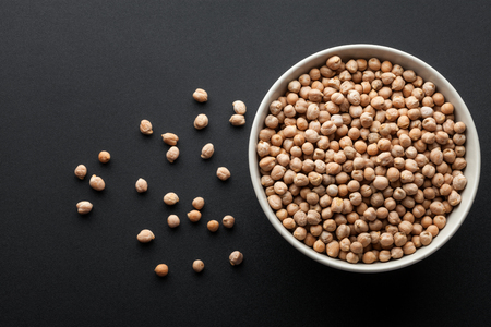 dry chickpeas in white bowl isolated on dark background. top viewの写真素材