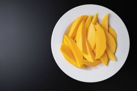 Slices of mango on a white and black backgroundの写真素材