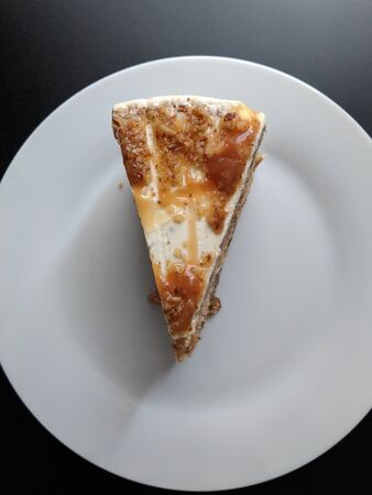 Slice of layers cake with vanilla cream and caramel topping