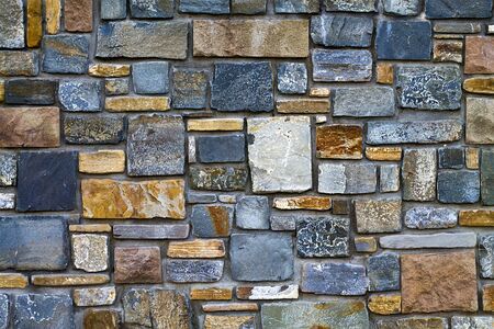 background decorative wall made of stones different form  closeupの写真素材
