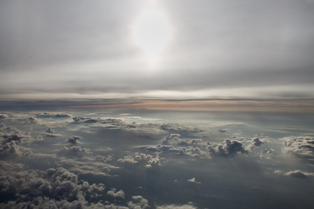 sun and clouds from an airplane windowの写真素材