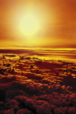 sun and clouds from an airplane window with an orange tintの写真素材
