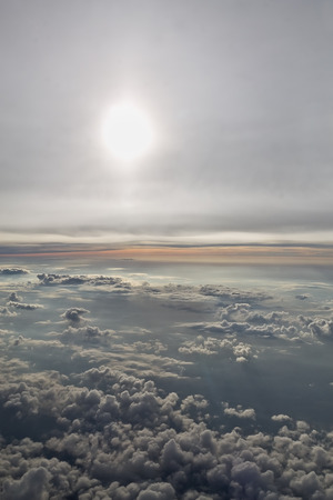 sun and clouds from an airplane windowの写真素材