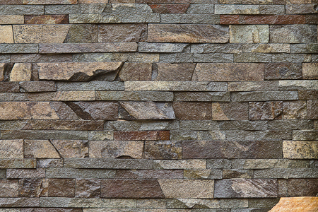 background decorative wall built of brown stone closeupの写真素材