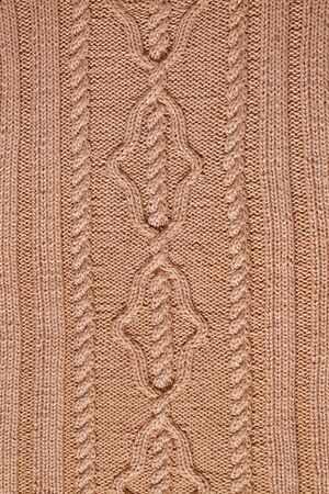 background beige knitted fabric with a pattern closeupの写真素材