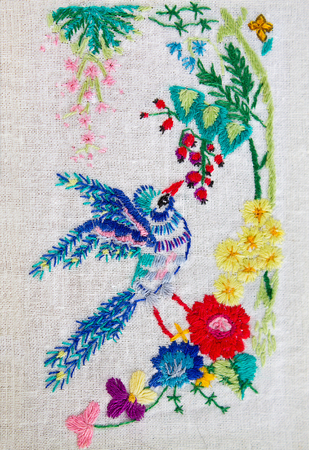 embroidered satin stitch bird with flowers closeupの写真素材