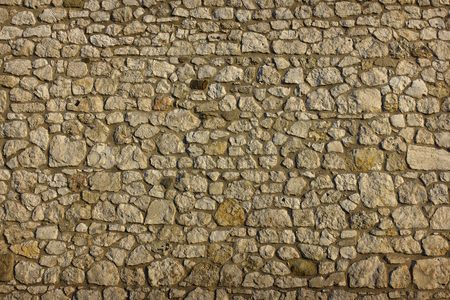 
background texture of an ancient masonry of uneven gray stones closeupの写真素材