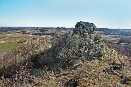 spring landscape with a rock and fieldsの写真素材
