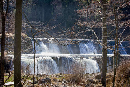 waterfall on a small river in the forest in early springの写真素材