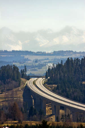 landscape with road and snow-capped mountains in the background. Polish Tatras