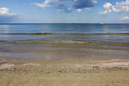 seascape with a sandy beach, sky and cloudsの写真素材