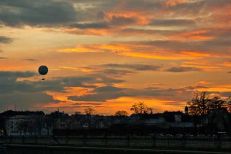 A bright orange sunset in Krakow, Poland. A city evening landscape with a balloon on the Vistula promenadeの写真素材