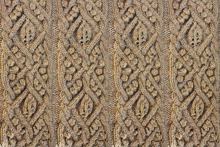 Beige background knitted fabric with a pattern. Knitted Arans close-upの写真素材
