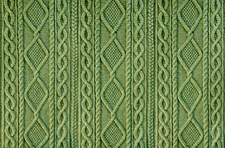 green background knitted fabric with a pattern. Knitted Arans close-upの写真素材