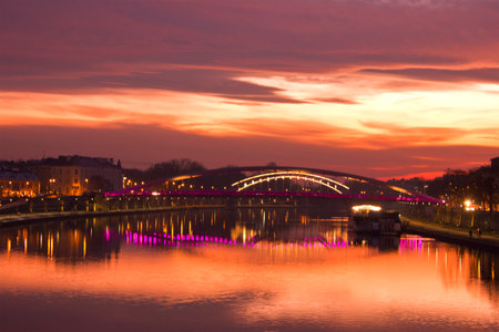 a purple sunset over the Vistula in Krakow.  Cityscape with river, bridge and evening lightsの写真素材