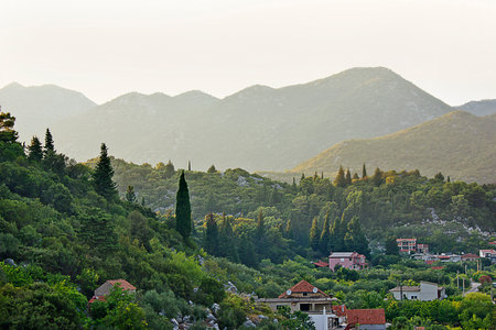 a village in a picturesque valley amongst the mountains. Landscape with mountains and cypressesの写真素材