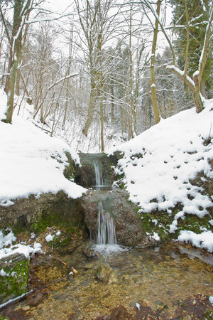 creek and a small waterfall in a winter snow-covered forest. Polish landscapeの写真素材