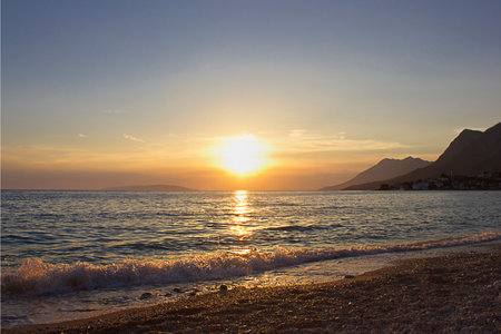 A seascape with the setting sun and the golden sea in the setting sunの写真素材