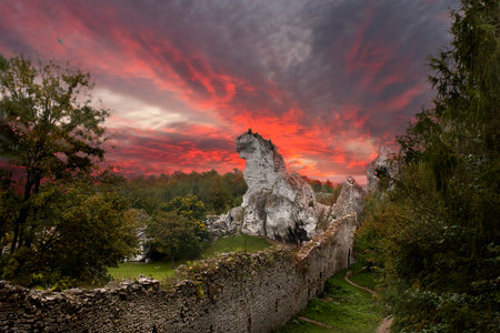 a landscape with a rock and a stone wall. A bright crimson sunset over the cliffの写真素材